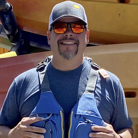 Gavin-Bio-Pic a man wearing glasses and smiling at the camera