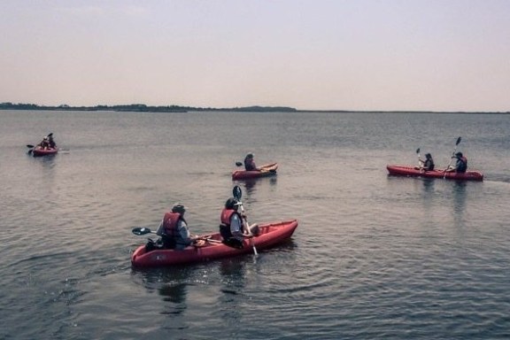 a group of people in a small boat in a body of water