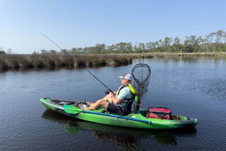 a little girl riding on the back of a boat in the water